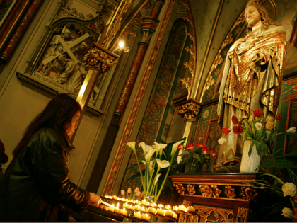 Worshippers light candles and pray next to a statue of Jesus in a Roman Catholic church in Amsterdam, Netherlands, Friday April 1, 2005. Pope John Paul II is in grave condition, the vatican said Friday, but it said he is lucid and spent the morning celebrating mass and receiving top …