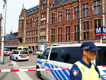 A security official stands beside a cordonned-off area at The Central Railway Station in Amsterdam on August 31, 2018, after two people were injured in a stabbing incident. - Two people were hurt during a stabbing incident at Amsterdam's busy Central Station with the alleged attacker shot and wounded, Dutch …