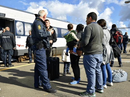 Refugees, mainly from Syria, speak with a Danish policeman after arriving in Rodby, southern Denmark, from Germany on September 7, 2015. Europe's migrant crisis has exposed sharp rifts in the 28-nation European Union, with Germany leading calls to take in many more people fleeing war and upheaval in the Middle …