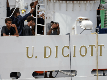 Migrants gather on the deck of the Italian Coast Guard vessel 'Diciotti' in the
