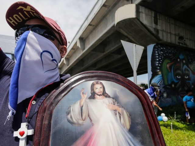 A man carries a religious image during a protest against Nicaraguan President Daniel Ortega's government in Managua, on September 15, 2018. (Photo by INTI OCON / AFP) (Photo credit should read INTI OCON/AFP/Getty Images)