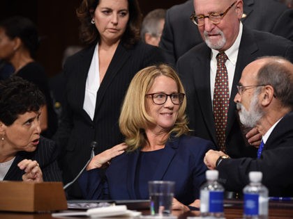 Christine Blasey Ford, the woman accusing Supreme Court nominee Brett Kavanaugh of sexually assaulting her at a party 36 years ago, chats with her attorneys as she testifies before the US Senate Judiciary Committee on Capitol Hill in Washington, DC, September 27, 2018. (Photo by SAUL LOEB / POOL / …