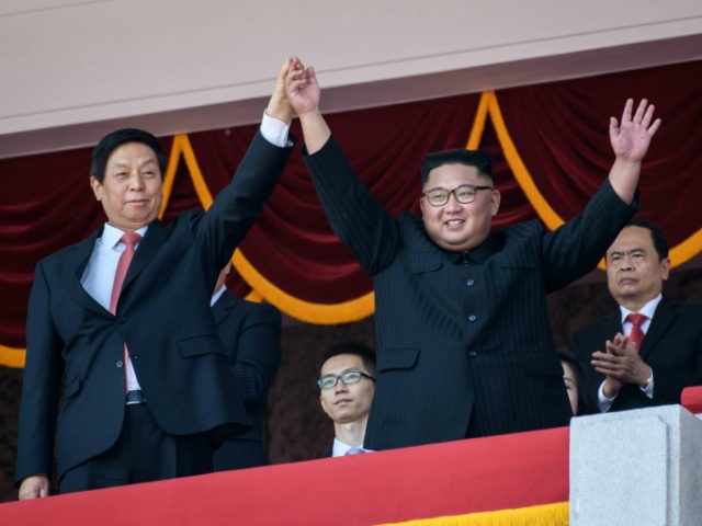 North Korea's leader Kim Jong Un (centre R) waves with China's Chairman of the Standing Co