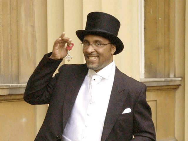 Former boxer Michael Watson, who was brain damaged in a fight with Chris Eubank 13 years ago, proudly displays his MBE, Wednesday, Feb. 11, 2004, after receiving the honour from Britain's Queen Elizabeth II, at an Investiture Ceremony at Buckingham Palace, London. Watson, 38, who doctors said would never walk again, stepped up unaided to receive the MBE in recognition of his work for disabled sport. (AP Photo/Chris Young/Pool)