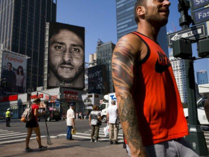 CORRECTS DATE- People walk by a Nike advertisement featuring Colin Kaepernick on display, Thursday, Sept. 6, 2018 in New York. Nike this week unveiled the deal with the former San Francisco 49ers quarterback, who's known for starting protests among NFL players over police brutality and racial inequality. (AP Photo/Mark Lennihan)