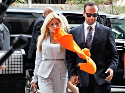 An orange shirt saying "inmate" is thrown by a protester at former Donald Trump presidential campaign foreign policy adviser George Papadopoulos, right, who triggered the Russia investigation, and who pleaded guilty to one count of making false statements to the FBI, as he holds hands with his wife Simona Mangiante …
