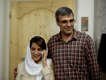 Iranian lawyer Nasrin Sotoudeh (L) speaks on the phone next to her husband Reza Khandan as