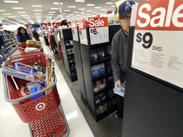FILE - In this Friday, Nov. 25, 2016, file photo, Paul Poirier shops at a Target store, in Wilmington, Mass. Target is lowering its fourth-quarter profit and sales outlook Wednesday, Jan. 18, 2017, after the discounter said that sluggish holiday sales and traffic in its stores offset a surging online …