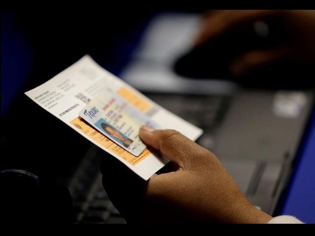 In this Feb. 26, 2014, file photo, an election official checks a voter's photo identification at an early voting polling site in Austin, Texas. A federal appeals court ruled Wednesday, July 20, 2016, that Texas' strict voter ID law discriminates against minorities and the poor and must quickly be scrubbed …
