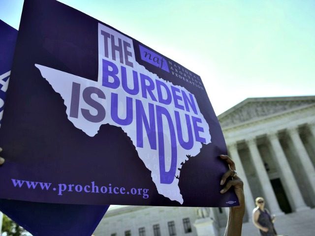An abortion rights activist holds a sign outside the U.S. Supreme Court earlier this year before the court struck down a Texas law placing restrictions on abortions. Now abortion rights supporters are suing the state again over a new rule.