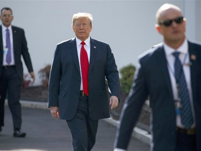 President Donald Trump walks to an interview on the North Lawn of the White House, Friday,