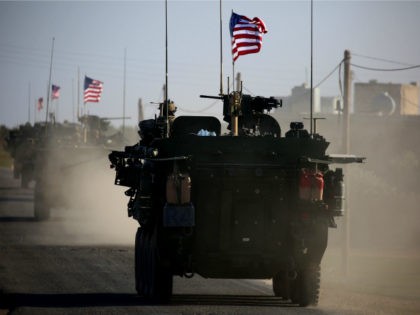 A convoy of US forces armoured vehicles drives near the village of Yalanli, on the western