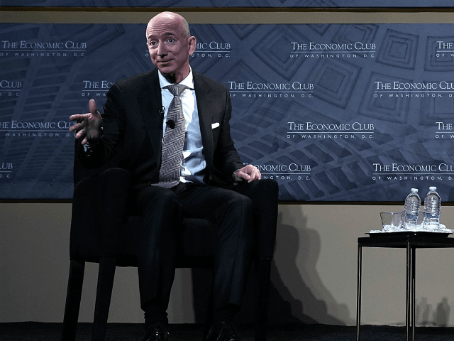 CEO and founder of Amazon Jeff Bezos (L) participates in a discussion with president of th