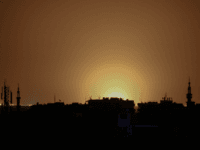 A photo taken from the rebel-held town of Douma shows flames rising in the distance which are believed to be coming from Damascus International Airport following an explosion early in the morning of April 27, 2017. It was not immediately clear if that blast that hit outside the airport was …