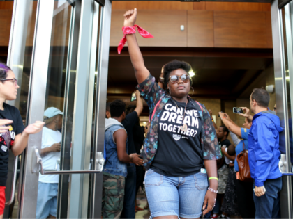 Protesters leave lthe lobby of the James Lawrence King Federal Justice Building where the U.S. Attorneys Office, Southern District of Florida, is located on August 14, 2014 in Miami, Florida. Eight who refused to leave were arrested. The protesters, which included members of the civil rights group Dream Defenders, say …