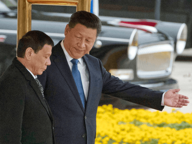 Chinese President Xi Jinping, right, shows the way to Philippine President Rodrigo Duterte