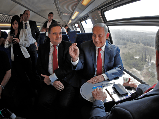 Israeli Prime Minister Benjamin Netanyahu (R) sits next to Israel's Transportation and Intelligence Minister Yisrael Katz during a test-run of the new high-speed train between Jerusalem and Tel Aviv, near Lod and Ben Gurion international Airport, on September 20, 2018. (Photo by Thomas COEX / AFP) (Photo credit should read …