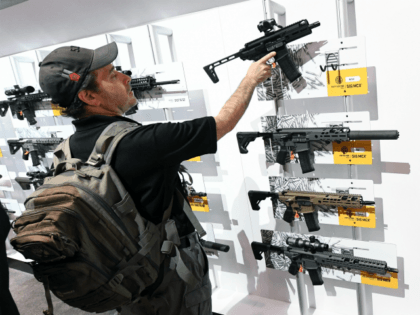 A convention attendee looks at rifles displayed at the Sig Sauer booth at the 2018 National Shooting Sports Foundation's Shooting, Hunting, Outdoor Trade (SHOT) Show at the Sands Expo and Convention Center on January 23, 2018 in Las Vegas, Nevada. The SHOT Show, the world's largest annual trade show for …