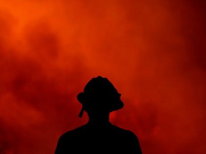A firefighter keeps watch on the Holy Fire burning in the Cleveland National Forest in Lake Elsinore, Calif., Thursday, Aug. 9, 2018. (AP Photo/Ringo H.W. Chiu)