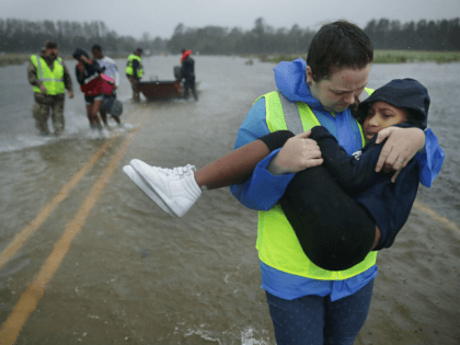 Volunteers from the Civilian Crisis Response Team help rescue three children from their fl