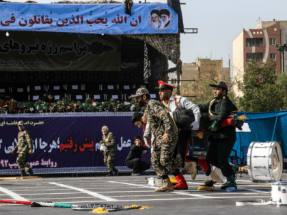 This picture taken on September 22, 2018 in the southwestern Iranian city of Ahvaz shows Iranian soldiers carrying away an injured comrade at the scene of an attack on a military parade that was marking the anniversary of the outbreak of its devastating 1980-1988 war with Saddam Hussein's Iraq. - …