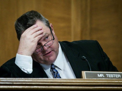WASHINGTON, DC - JANUARY 30: Senator Jon Tester (D-MT) looks on as Treasury Secretary Stev