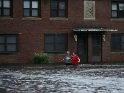 Residents wade through deep floodwater to retrieve belongings from the Trent Court public housing apartments after the Neuse River went over its banks during Hurricane Florence September 13, 2018 in New Bern, United States. Coastal cities in North Carolina, South Carolina and Virginia are under evacuation orders as the Category …