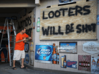 MYRTLE BEACH, SC - SEPTEMBER 12: Doug Lewis (L) and Chris Williams use plywood with the words 'Looters will be shot' to cover the windows of Knuckleheads bar as they try to protect the business ahead of the arrival of Hurricane Florence on September 12, 2018 in Myrtle Beach, United States. Hurricane Florence is expected on Friday possibly as a category 4 storm along the Virginia, North Carolina and South Carolina coastline. (Photo by Joe Raedle/Getty Images) MYRTLE BEACH, SC - SEPTEMBER 12: Doug Lewis (L) and Chris Williams use plywood with the words 'Looters will be shot' to cover the windows of Knuckleheads bar as they try to protect the business ahead of the arrival of Hurricane Florence on September 12, 2018 in Myrtle Beach, United …