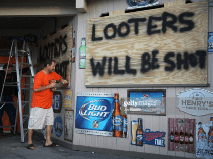 MYRTLE BEACH, SC - SEPTEMBER 12: Doug Lewis (L) and Chris Williams use plywood with the words 'Looters will be shot' to cover the windows of Knuckleheads bar as they try to protect the business ahead of the arrival of Hurricane Florence on September 12, 2018 in Myrtle Beach, United …