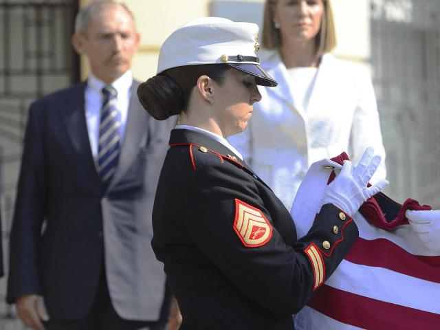 Marines fold the American flag in front of Hungarian Interior Minister Sandor Pinter, left
