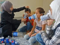 preparation-homemade-gas-masks-syria-idlib-sept-18-getty TOPSHOT - Um Majid (L) tries an improvised gas mask on familiy members in her home in Binnish in Syria's rebel-held northern Idlib province as part of preparations for any upcoming raids on September 12, 2018. - The Syrian regime and its Russian ally are threatening an offensive to retake …