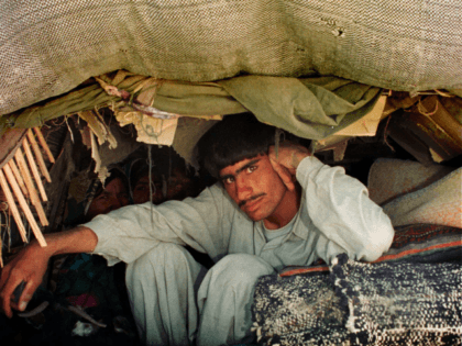 Afghan refugees hide in the back of a truck as they sneak into Xahedan, a city in south Iran on the border with neighboring Afghanistan as allied forces bomb Afghanistan, October 8, 2001. Iranian security forces believe that more refugees will take refuge from the ruling Taliban regime in Afghanistan, …
