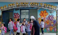 Pupils and teachers gather in front of a school run by the UN agency for Palestinian refugees UNRWA in the Balata refugee camp of the occupied West Bank on August 29, 2018