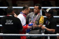 North Korean boxing coach Pak Chol Jun is restrained by a policeman and security officials after boxer Pang Chol Mi lost a final on Saturday. He was thrown out of the Asian Games