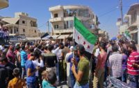 Syrians chant slogans and wave flags of the opposition as they protest against the regime and its ally Russia, in Binnish in Syria's rebel-held northern Idlib province on August 31, 2018