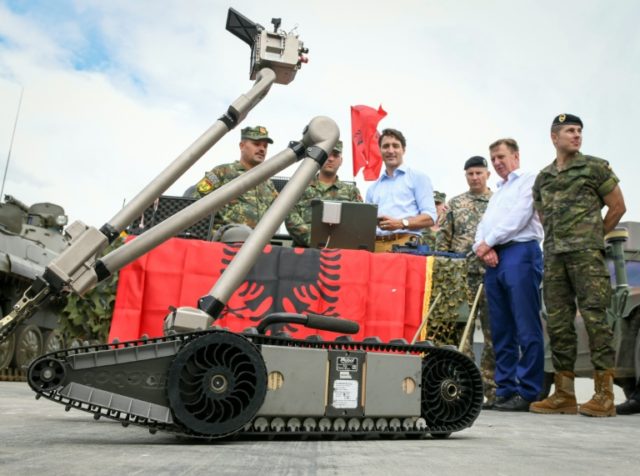 Perdana Menteri Kanada Justin Trudeau, tengah, memeriksa robot militer yang dikerahkan bersama pasukan NATO di Latvia pada Juli 2018