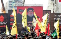 Supporters of Lebanon's Shiite movement Hezbollah gather near a poster of their leader Hassan Nasrallah during a ceremony to mark Ashura in Beirut on September 20, 2018
