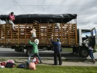 A Venezuelan migrant family get off a truck on the Pan-American highway, between Pasto and Ipiales in Colombia, on August 23, 2018. Flood of Venezuela migrants costing Colombia 0.5% of GDP: president