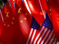 China US Tariffs In this Sept. 16, 2018, photo, American flags are displayed together with Chinese flags on top of a trishaw in Beijing. The American Chamber of Commerce in China says Beijing will "dig its heels in" after U.S. tariff hikes and appealed for a negotiated end to their trade battle. The chamber on Tuesday, Sept. 18 warned a "downward spiral" appears certain after President Donald Trump approved a tariff hike on $200 billion of Chinese imports in a dispute over Beijing's technology policy. (AP Photo/Andy Wong) The Associated Press