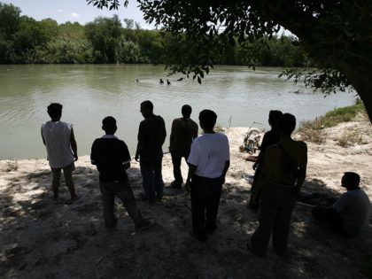 After thirty days crossing Mexico, a group of Honduran migrants watch from the Mexican sid