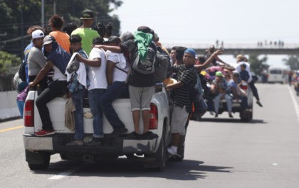 Central American migrants making their way to the U.S. in a large caravan cling to the tru