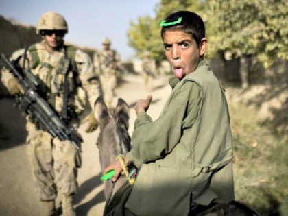 A boy on a donkey reacts as Canadian soldiers with the 1st RCR Battle Group, The Royal Canadian Regiment, patrol in Salavat, southwest of Kandahar, on September 11, 2010. Minutes later the soldiers were attacked by grenades while leaving the village.
