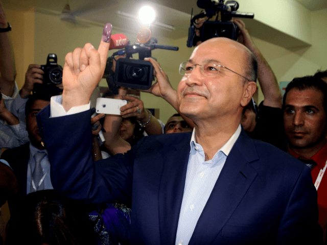 Barham Salih (R), a senior PUK politician who has held multiple top positions including prime minister of the Kurdish region shows his ink-stained finger after voting in the Kurdistan's legislative election at a polling station on September 21, 2013 in the northern Kurdish city of Sulaimaniyah. Iraq's Kurds vote for …
