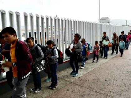 People line up to cross into the United States to begin the process of applying for asylum near the San Ysidro port of entry in Tijuana, Mexico, in July.