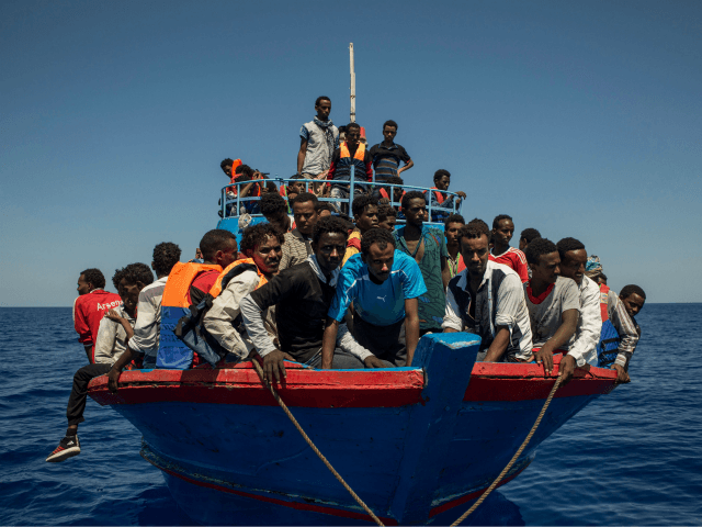 TOPSHOT - Migrants wait to be rescued by the Aquarius rescue ship run by non-governmental organisations (NGO) 'SOS Mediterranee' and 'Medecins Sans Frontieres' (Doctors Without Borders) in the Mediterranean Sea, 30 nautic miles from the Libyan coast, on August 2, 2017. Italy on August 2, 2017 began enforcing a controversial â€¦