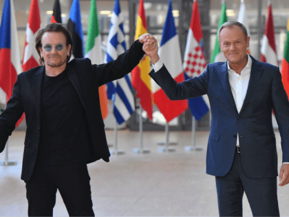 Irish rock band U2 singer Bono (L) poses with European Council President Donald Tusk upon his arrival at the European Council in Brussels on October 10, 2018. - Bono, the co-founder of ONE, a global campaign and advocacy organisation committed to ending extreme poverty, is in Brussels to discuss African …