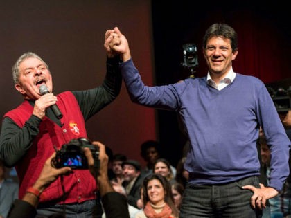 Brazilian former president Luiz Inacio Lula da Silva (L) raises the hand of the mayoral candidate of the Workers Party (PT) Fernando Haddad during a campaign rally in Sao Paulo, Brazil, on September 27, 2012. The Sao Paulo mayoral race pits an ex-television consumer advocate against candidates of Brazil's two …