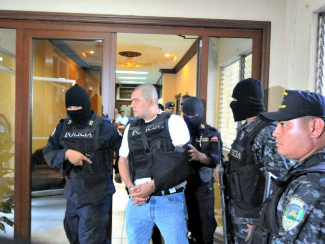 Alleged drug trafficker Mario Ponce Rodriguez (C) --whose extradition has been requested by the US-- is taken under custody to a hearing in court in Tegucigalpa on October 10, 2011.