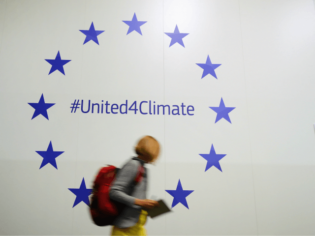 BONN, GERMANY - NOVEMBER 07: A participant walks past European Union stars advertising an