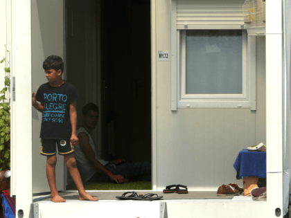 BERLIN, GERMANY - JULY 18: A refugee child stands on the porch of a shipping container in